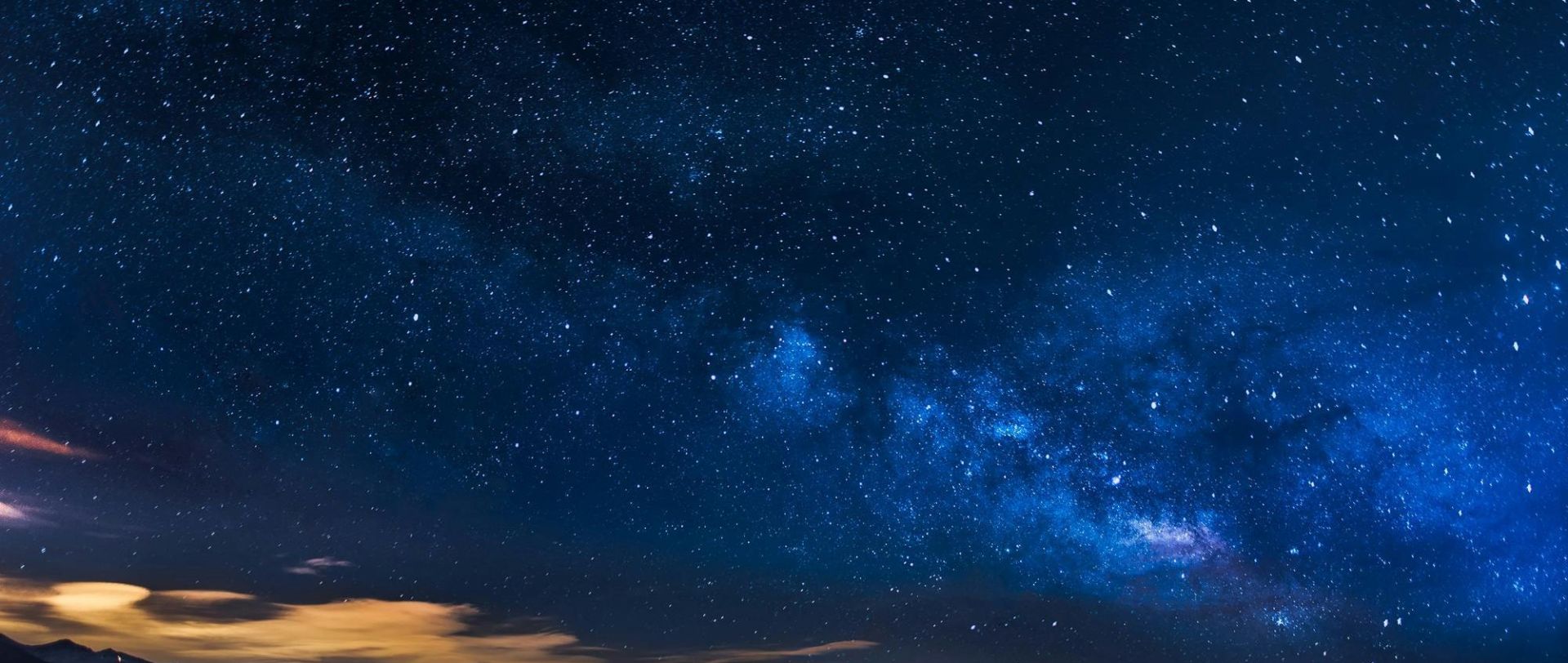 A breathtaking view of the Milky Way galaxy illuminating the night sky over mountains.